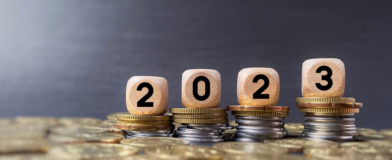 Cubes spelling out the year 2023 on top of a pile of UK currency.